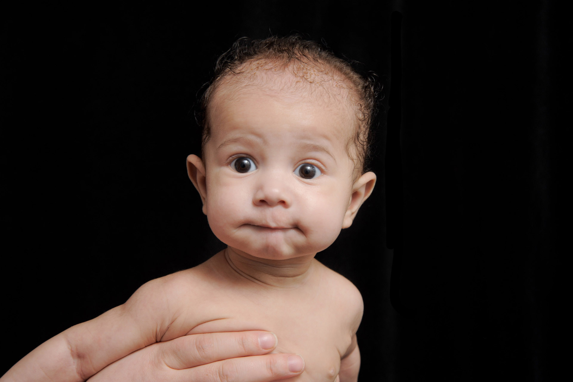 Best Detroit baby photographer's fun and candid infant photos of a baby outstretched in his mom's arms in Troy, Michigan.