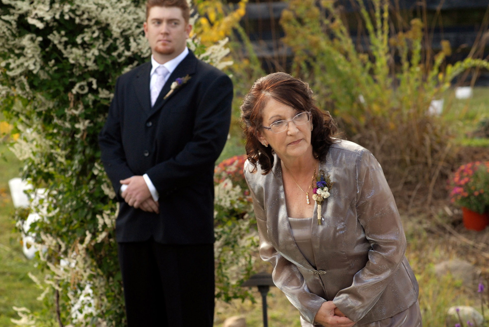 Favorite Michigan backyard wedding photography features photojournalist photos of the mother of the groom looking to see where the bride is from her vantage point down the aisle in metro Detroit, Michigan featuring their lovely backyard garden wedding in fall.