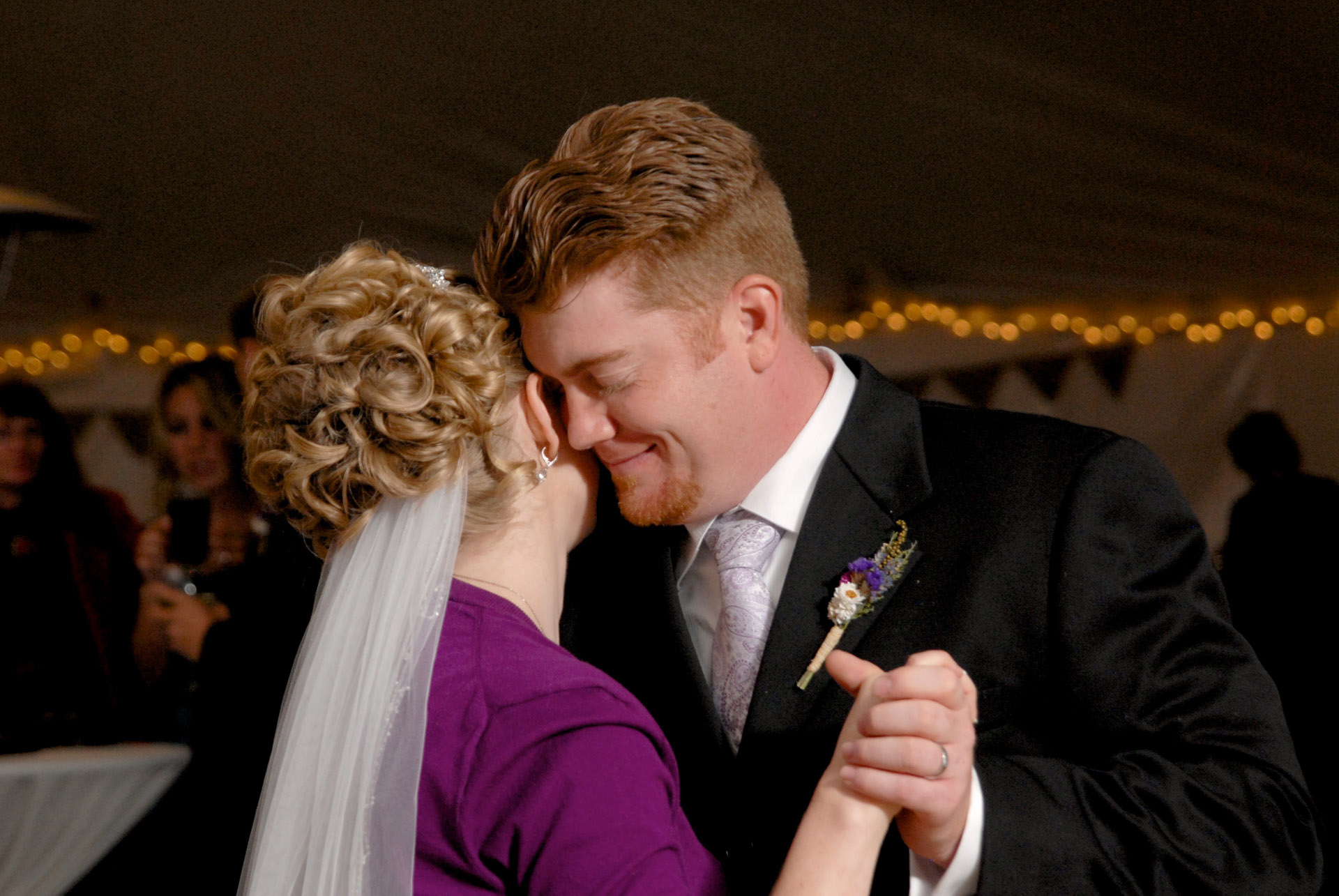 Best Michigan backyard wedding photography features photojournalist photos of the bride and groom sharing their first dance in a tent after their wedding in metro Detroit, Michigan featuring their lovely backyard garden wedding in fall.