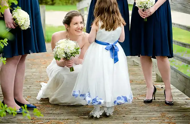 A bride squats down to chat with her flower girl at Ann Arbor's Stonebridge Golf Course.