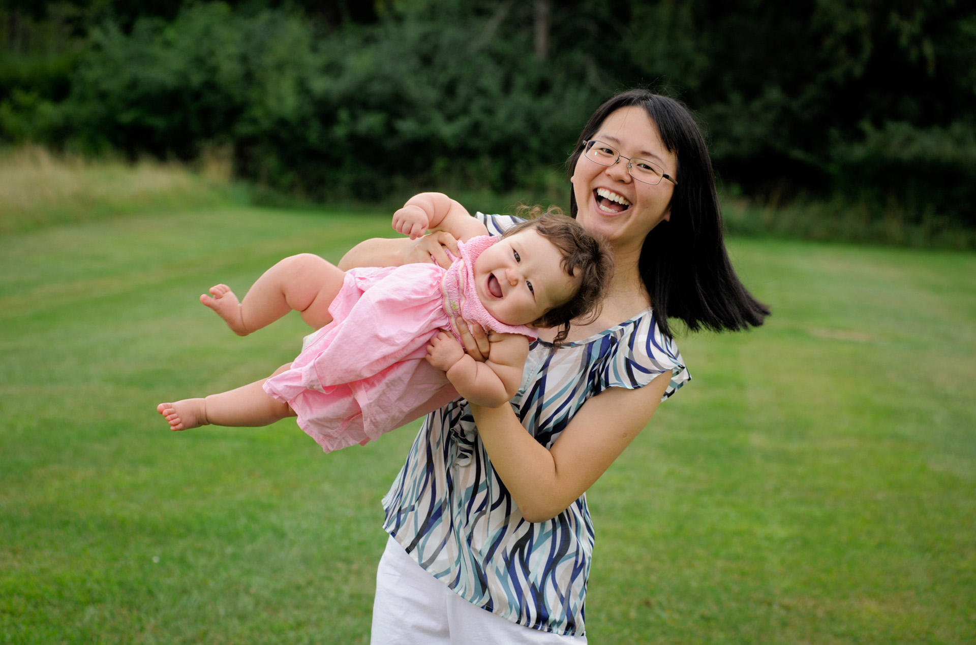 Best Troy lifestyles photographer's fun and candid children's and kids photos of one family like this mother swinging her daughter taken in Metro Detroit and Troy, Michigan.