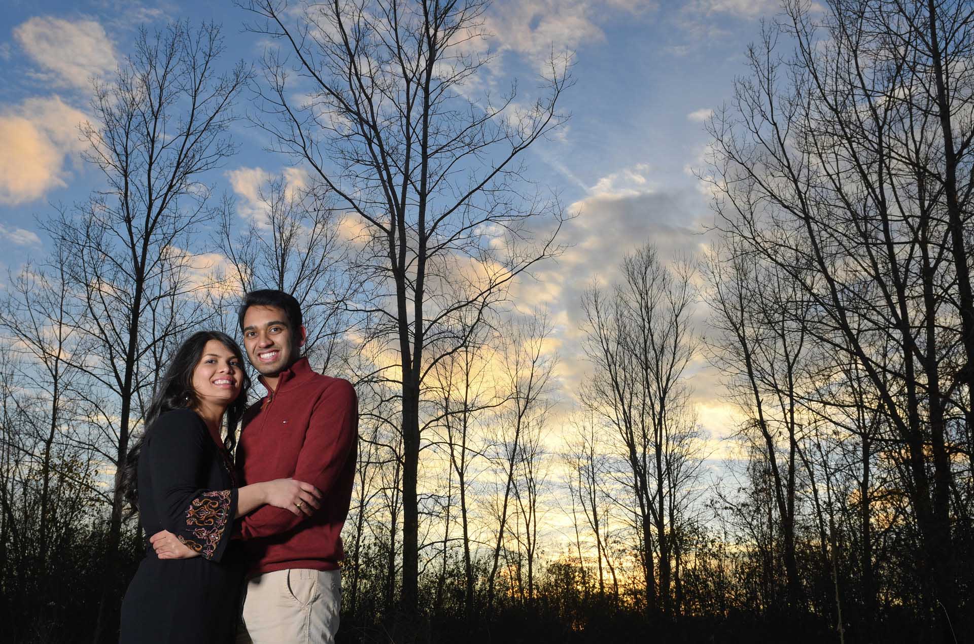 Best Troy lifestyles photographer takes a photo of a engaged couple snuggling at sunset at a park in the Metro Detroit and Troy, Michigan area.